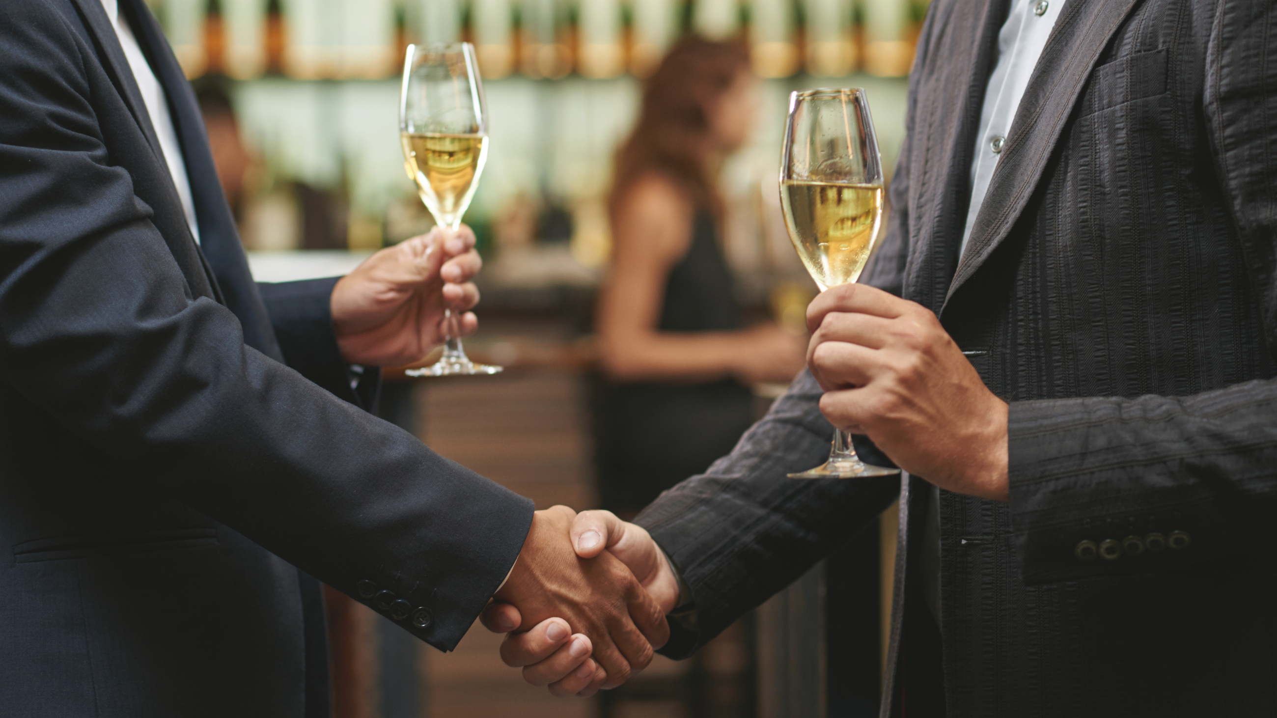 Handshake with wine glasses